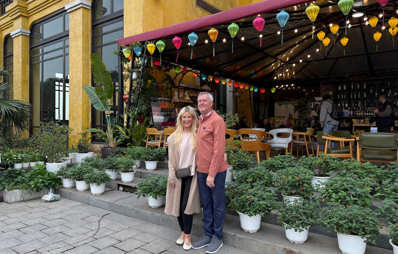 Couple standing in front of a lantern-decorated café in Hoi An, Vietnam